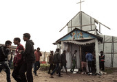 مهاجرون شبان يصلون في كنيسة مخيم 