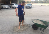 بالصور... شاب يبادر بردم الحفر بمنطقة القدم بعد تضرر سيارات الأهالي والمقيمين